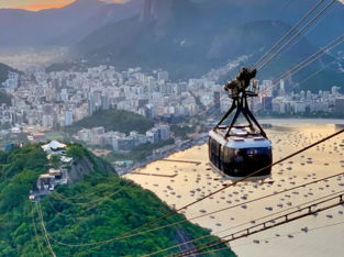 white cable car traversing on top of hills overlooking city by bay